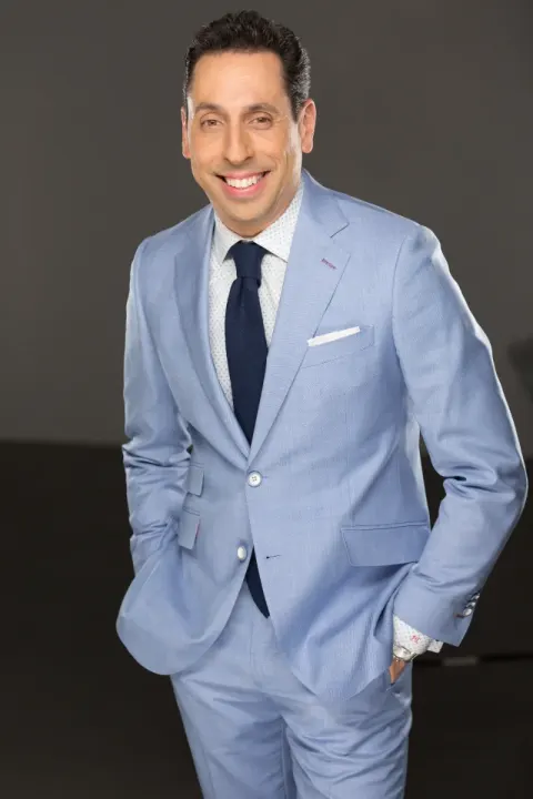 Jess Todtfeld in a light blue suit and navy tie, hands in pockets