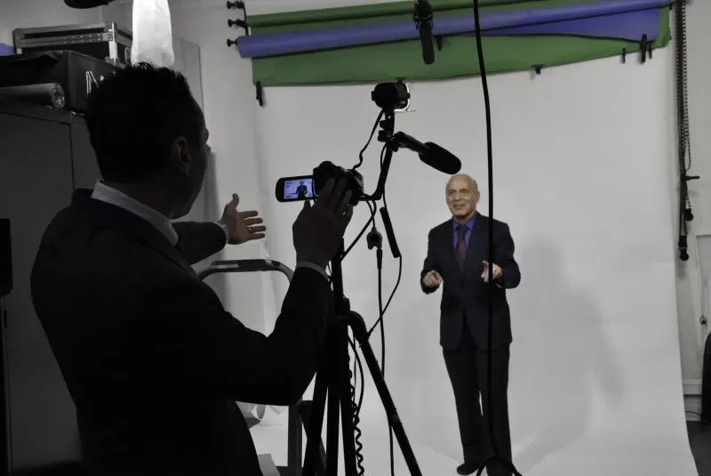 Jess Todtfeld behind the camera, filming a client on a white studio set