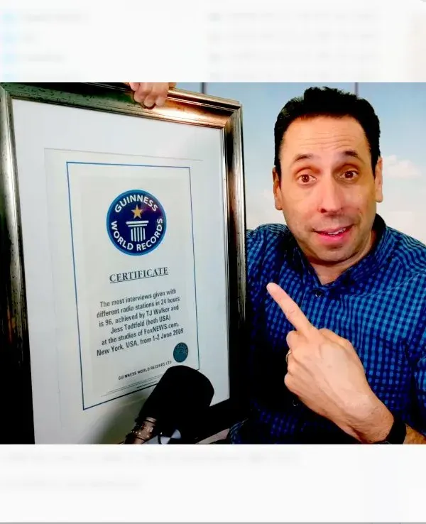Jess Todtfeld pointing at the framed Guinness World Records certificate