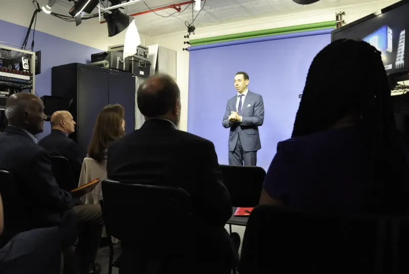 Jess Todtfeld coaching at a studio backdrop while a team of trainees watches